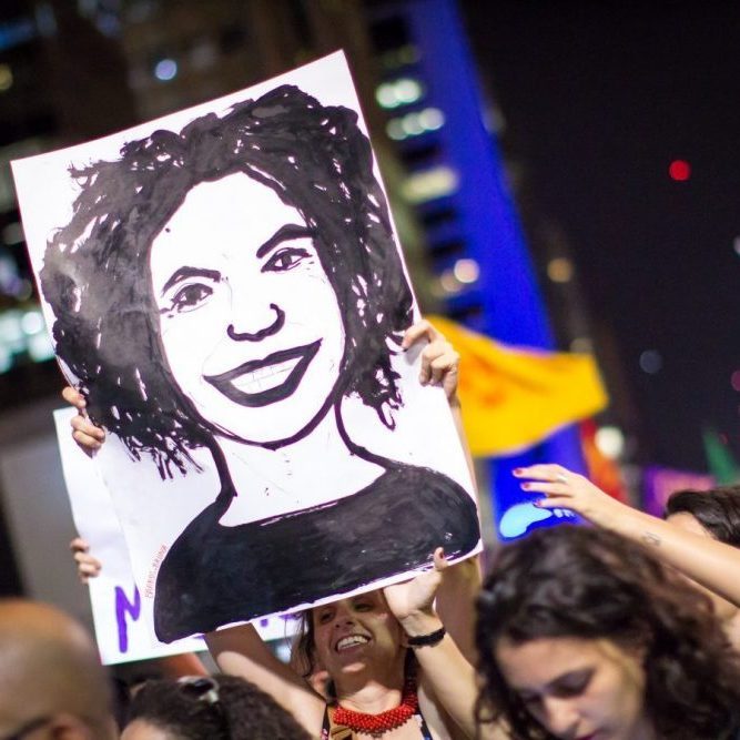 Demonstrator hold drawing of Marielle Franco Face