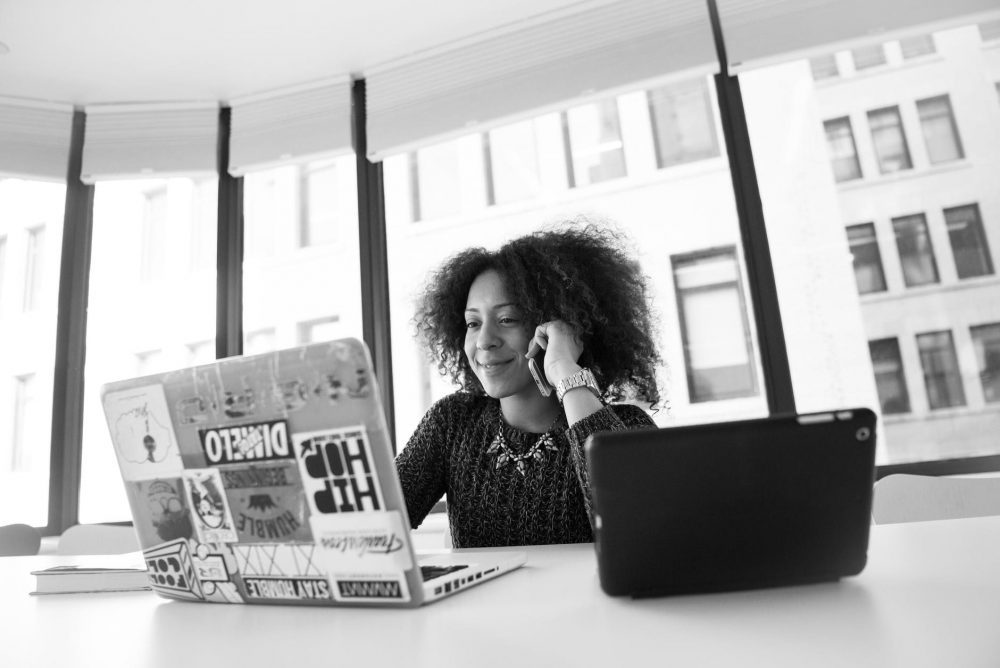 Woman of colour looking int olaptop and smiling 
