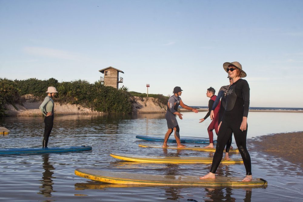 women standing on surf boards