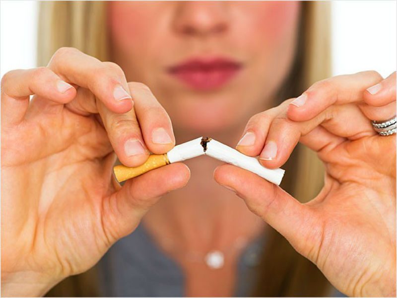 woman breaking cigarette in half