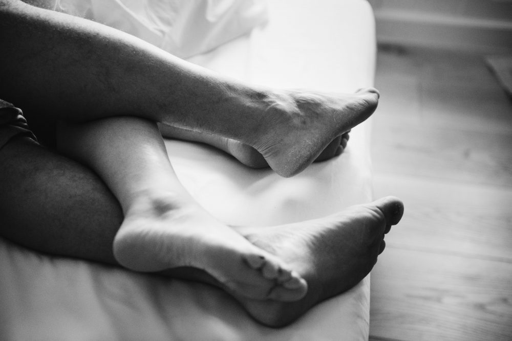 2 pair of naked legs in bed 